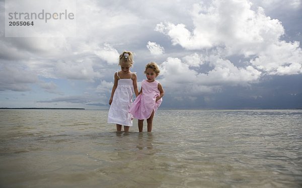 Zwei junge Mädchen  die im Meer stehen.