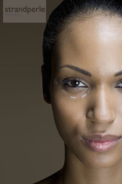 Eine Frau mit kosmetischen Operationsspuren unter dem Auge.