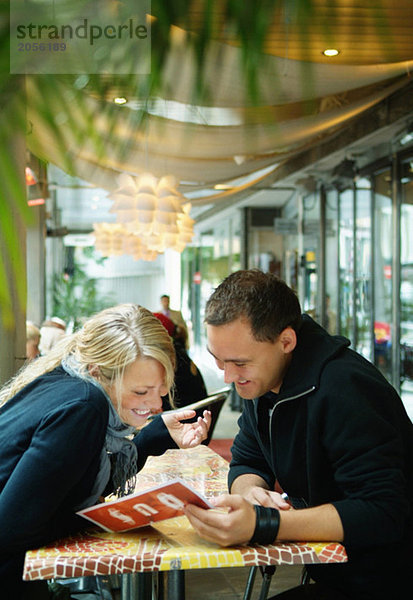 Mädchen und Kerl sitzen in einem Restaurant.