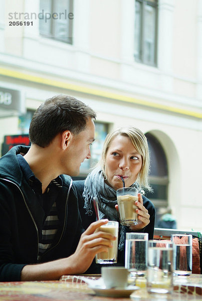 Mädchen und Kerl sitzen in einem Café.