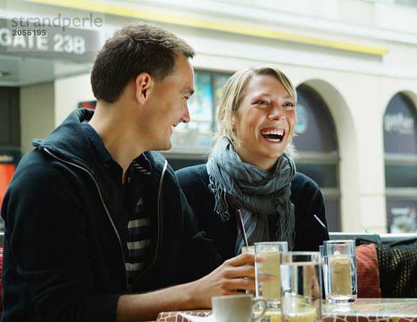 Mädchen und Kerl in einem Café lachend