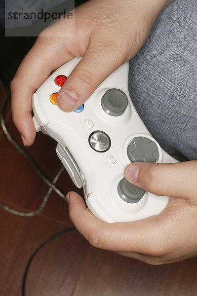 Ein Junge hält eine weiße Videospielsteuerung in den Händen