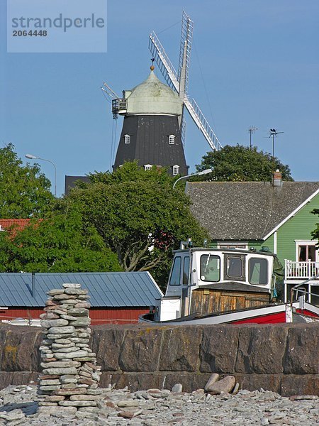 Stapel Steine an der K??ste mit traditionellen Windmühle im Hintergrund  Oland  Schweden
