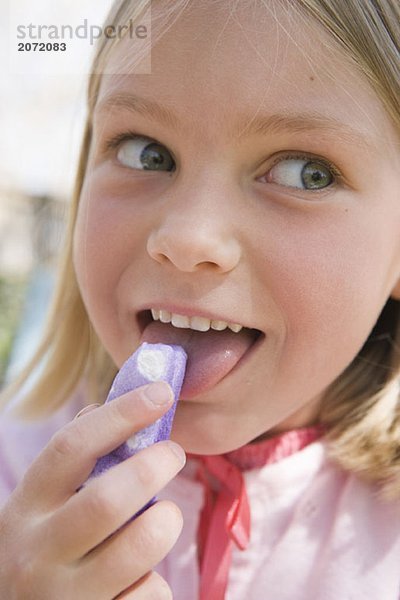 Ein kleines Mädchen isst Süßigkeiten