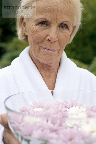 Deutschland  Seniorin mit Blumenschale  Portrait