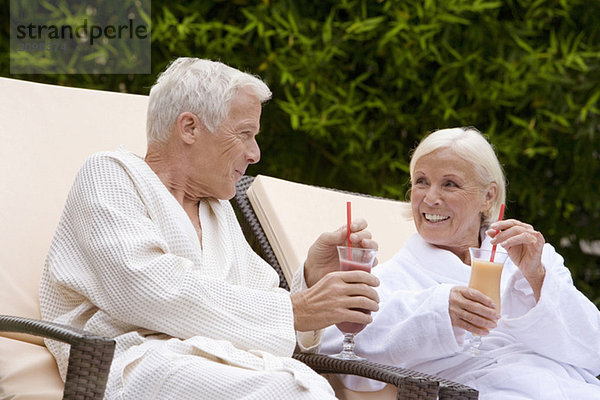 Deutschland  Seniorenpaar trinkt Smoothie im Spa