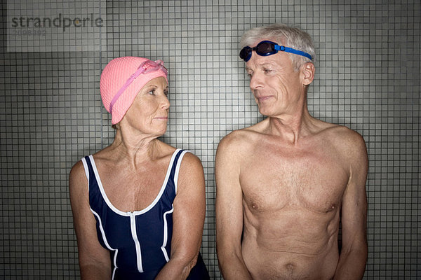 Seniorenpaar im Umkleideraum mit Bademütze und Schutzbrille