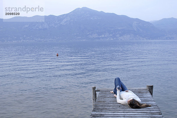 Italien  Gardasee  Junge Frau (20-25) am Steg liegend