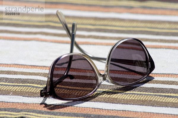 Sonnenbrille auf gestreiftem Stoff  Nahaufnahme