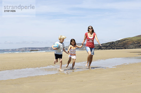 Frau mit ihren Kindern am Strand