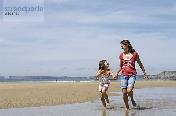 Frau mit ihrer Tochter am Strand