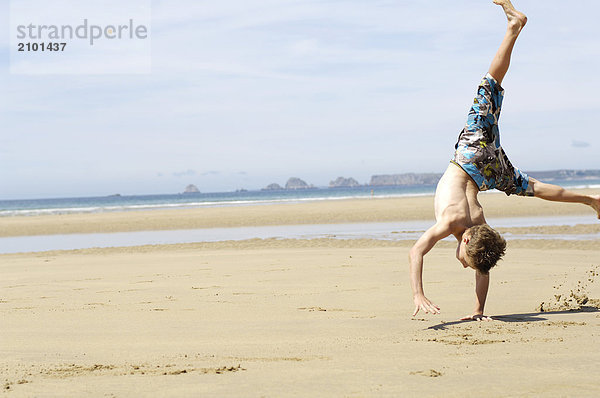 Boy doing Cartwheel am Strand
