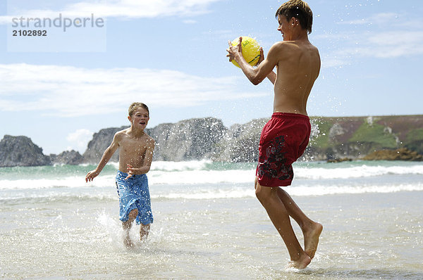 Strand Junge - Person 2 Ball Spielzeug spielen