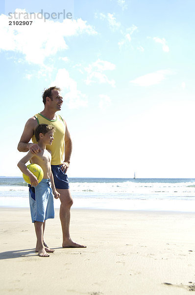 Vater Standing mit seinem Sohn am Strand