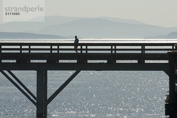 Silhouette of a man walking along a pier  Sidney  BC  Canada