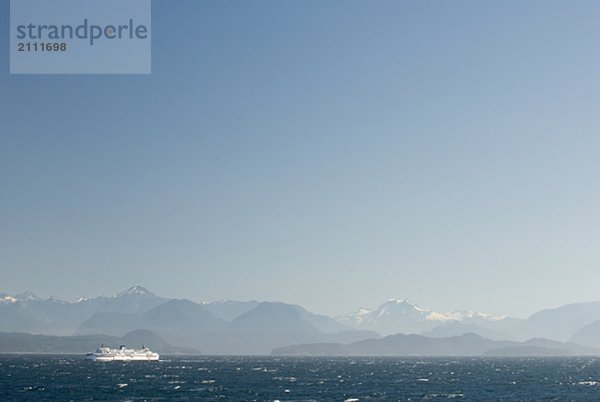 Ferry boat makes a crossing in rough seas with mountains in the background  BC Ferries  Nanaimo  BC  Canada