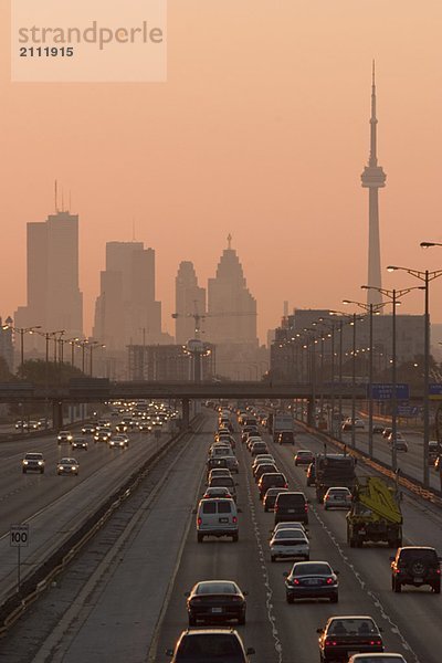 View of Toronto skyline from above Queen Elizabeth Way highway during start of rush hour traffic  Toronto  Ontario  Canada.