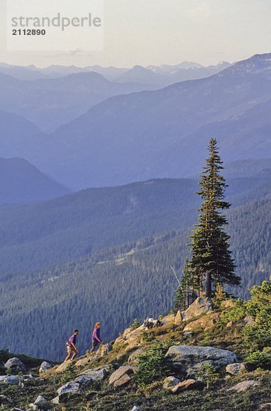 Couple hiking on Whistler Mountain  with coast mtn range in back