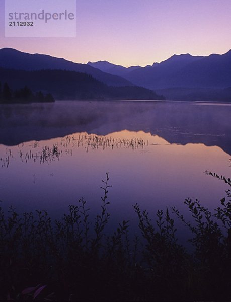 Sunrise glows purple in the reflection  Green Lake  Whistler  BC