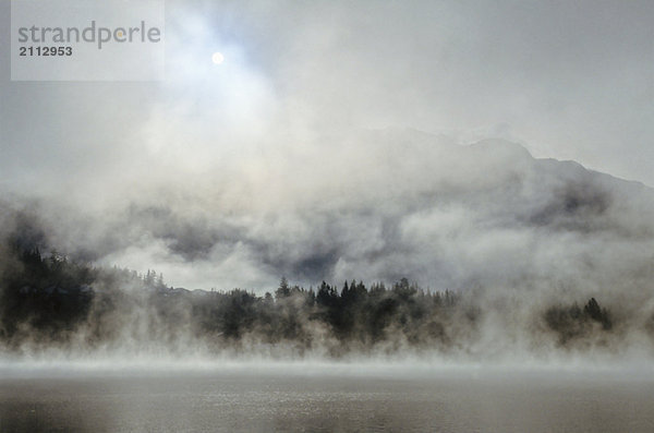 Whistler Mountain rises above Alta Lake on misty morning  Whistler  BC Canada