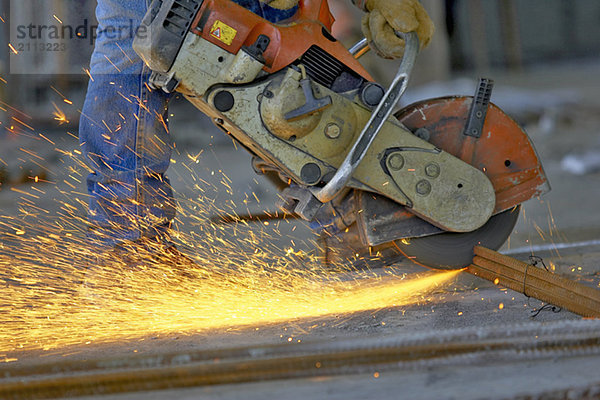 'Circular metal saw (chop saw) cutting metal rebar bundle causing sparks