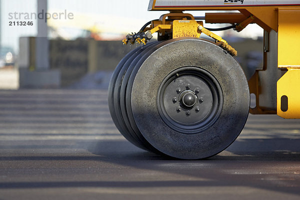 'Wheels of paving roller on new asphalt