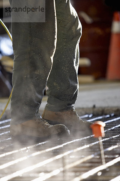 'Worker walking on concrete form made of rebar
