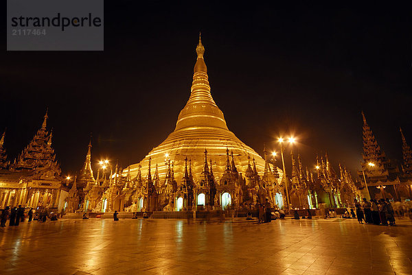 Gruppe von Menschen in Buddhisten-Tempel beleuchtet während der Dämmerung  Shwedagon Pagode  Rangun  Myanmar