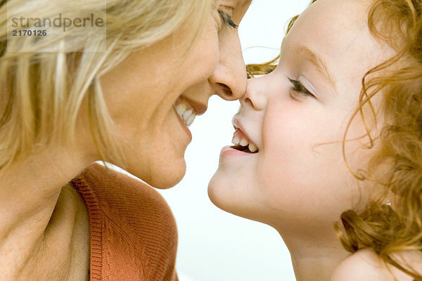 Mutter und Tochter berühren Nasen und lächeln sich an  Ausschnittansicht