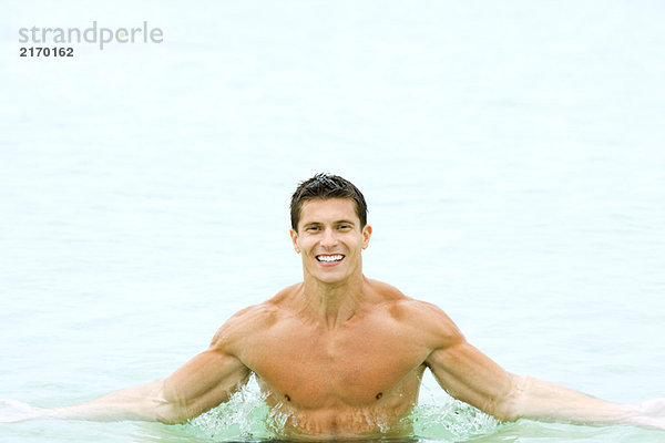Mann im Schwimmbad  lächelnd vor der Kamera  Porträt