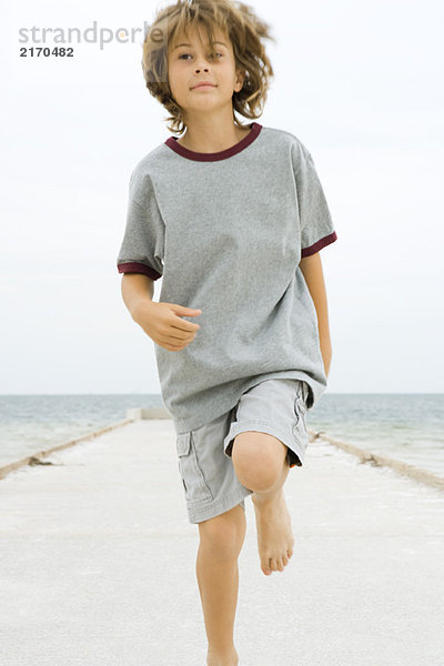 Junge rennt auf dem Pier  schaut weg  Nahaufnahme