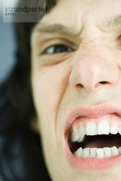 Teenager-Junge beim Zähne fletschen  Blick in die Kamera  extreme Nahaufnahme