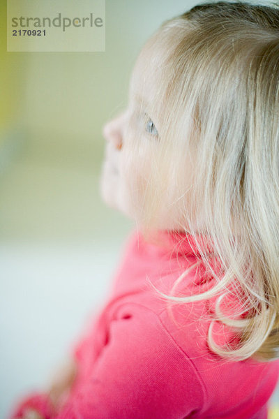 Blondes Kleinkind Mädchen schaut nach oben  Seitenansicht