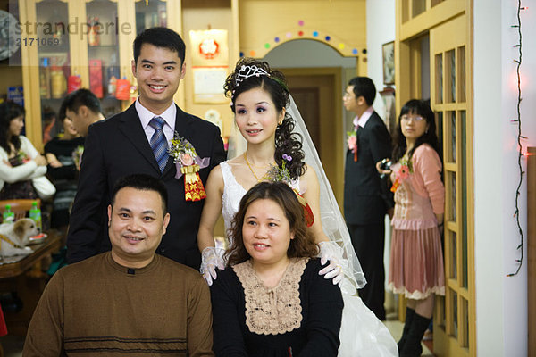 Braut und Bräutigam stehen hinter dem Paar  lächelnd  Portrait