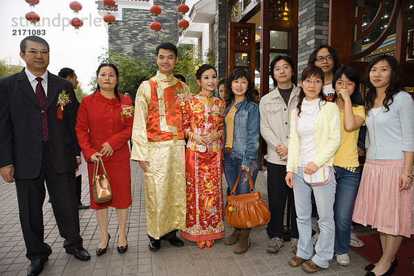 Neuvermählte in traditioneller chinesischer Kleidung  stehend mit Familie  Gruppenbild