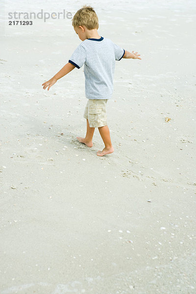 Kleiner Junge am Strand mit ausgestreckten Armen  volle Länge