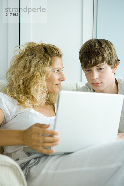 Frau und jugendlicher Sohn mit Laptop