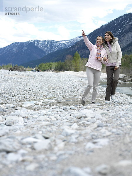 Zwei junge Frauen zu Fuß am Flussufer