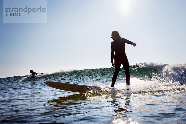 Mann und Frau beim Surfen.