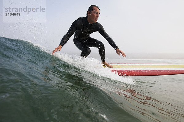 Ein Mann  der auf einer Welle surft.