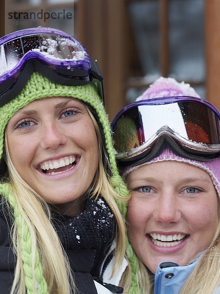 Zwei junge blonde Frauen in Skikleidung  Nahaufnahme  Porträt