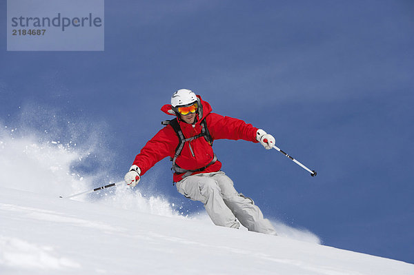 Mann beim Skifahren auf der schneebedeckten Piste  Blick in den tiefen Winkel