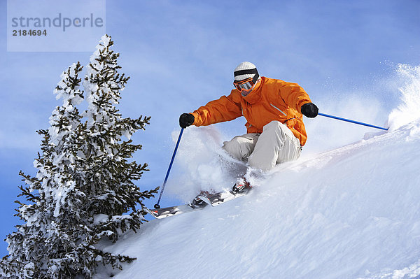 Österreich  Saalbach  Mann beim Skifahren über den Grat am Hang