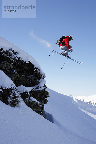 Österreich  Saalbach  Skispringen über Felsen auf verschneiter Piste