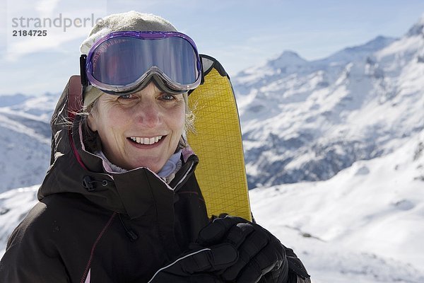 Reife Skifahrerin mit Skiern am Berg  Nahaufnahme  Portrait
