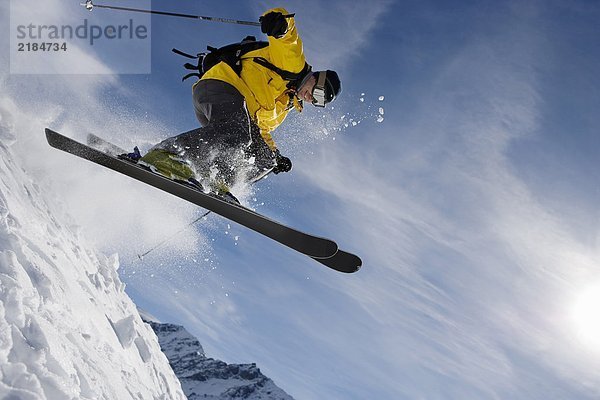 Männliches Skifahren über den Bergrücken
