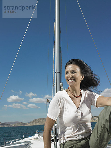Reife Frau entspannt auf der Yacht  lächelnd