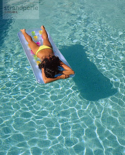 Eine Frau  die in einem Pool auf dem Bauch schwimmt.