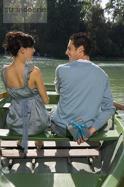 Mann und Frau in einem Boot mit einem Geschenk
