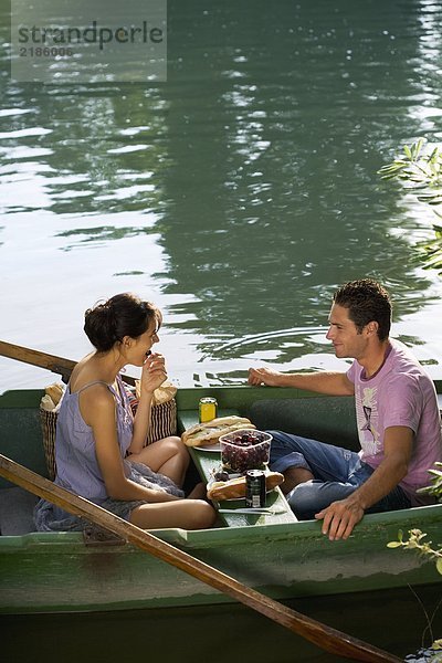 Mann und Frau beim Picknick auf dem Boot